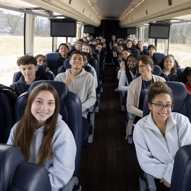 Group boarding a white charter bus for School Transportation transportation in Las Vegas